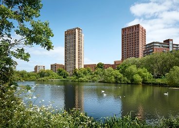 Modern lakeside residential towers with lush greenery and water views